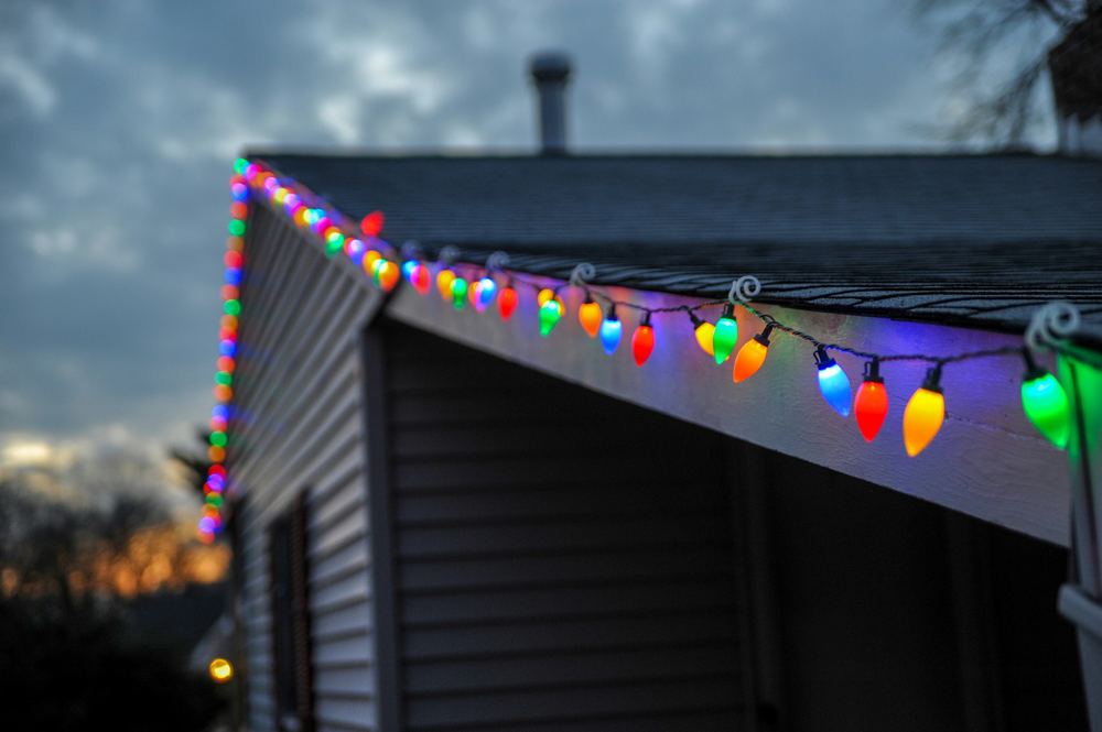 Colorful holiday lights installed along a roofline